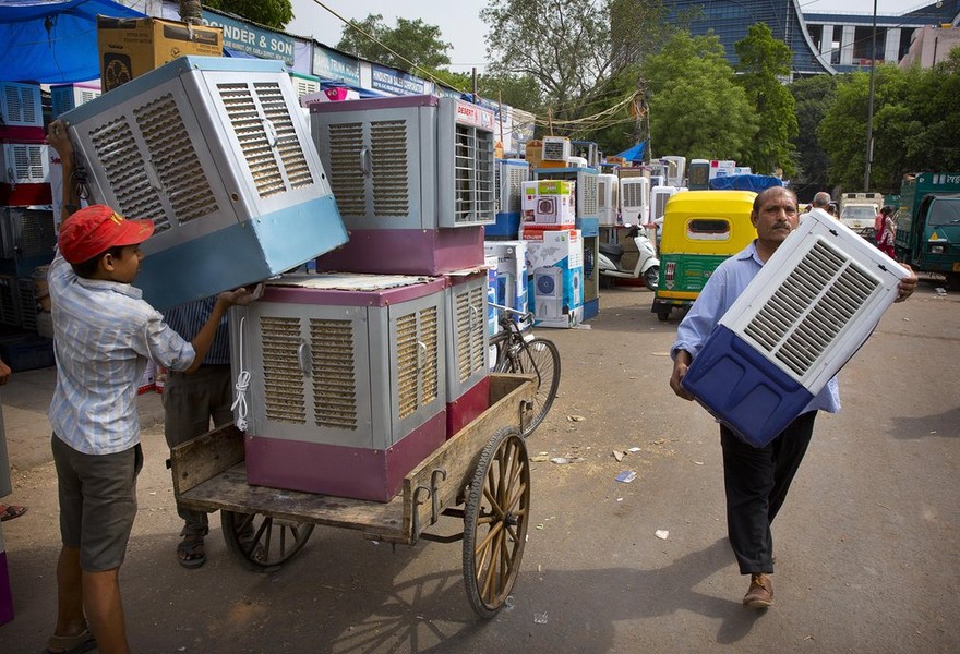 Các tiểu thương mang máy làm mát không khí ra chợ bán ở New Delhi.